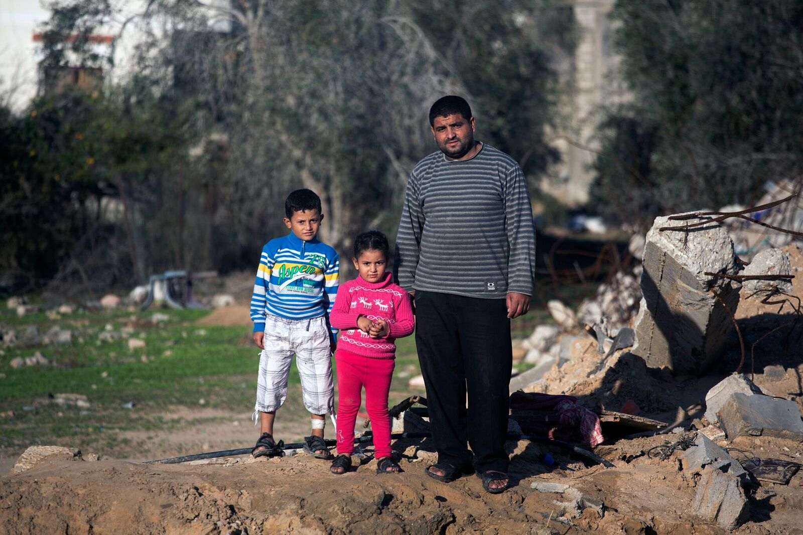 Hussein, einer von nur drei Menschen die die Bombardierung seines Hauses überlebten, mit seinen Kindern Husam und Olfat.
