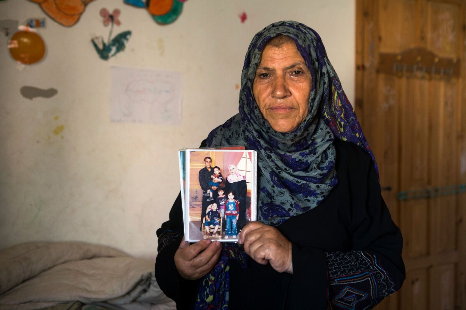 Khadija, la sœur d’Ibrahim, tient une photo de son frère et de sa famille.
