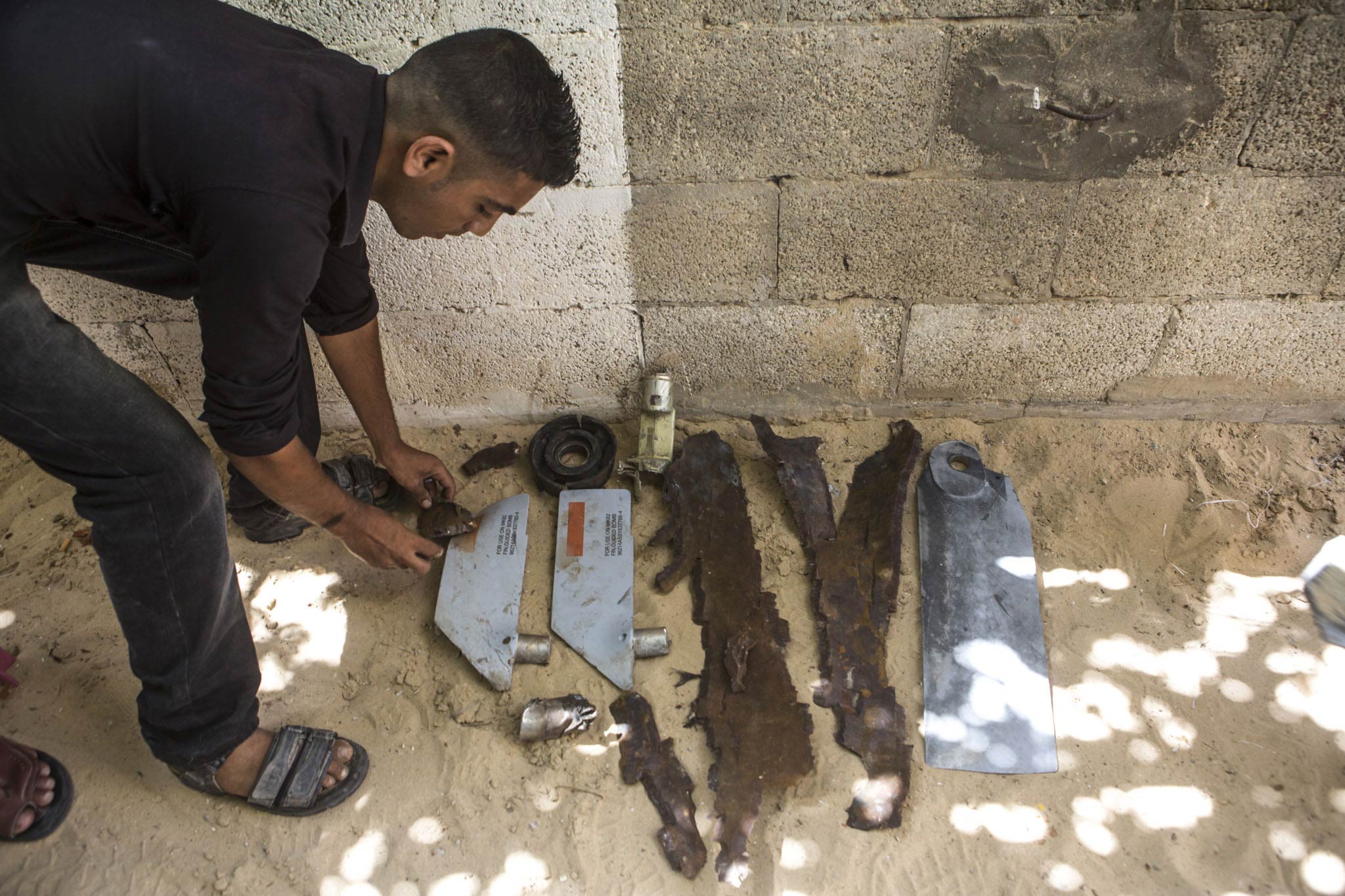 Teile der Bombe, die auf das Haus der al-Louhs fiel. Die grauen Teile sind Finnen einer selbststeuernden Rakete, einer sogenannten „smart bomb“ oder auch: „präzisionsgelenkte Munition“. Diese Finnen helfen bei der Steuerung, so dass die Bombe ihr Ziel genau trifft – in diesem Fall das Haus mit Rafats schlafender Familie. 
